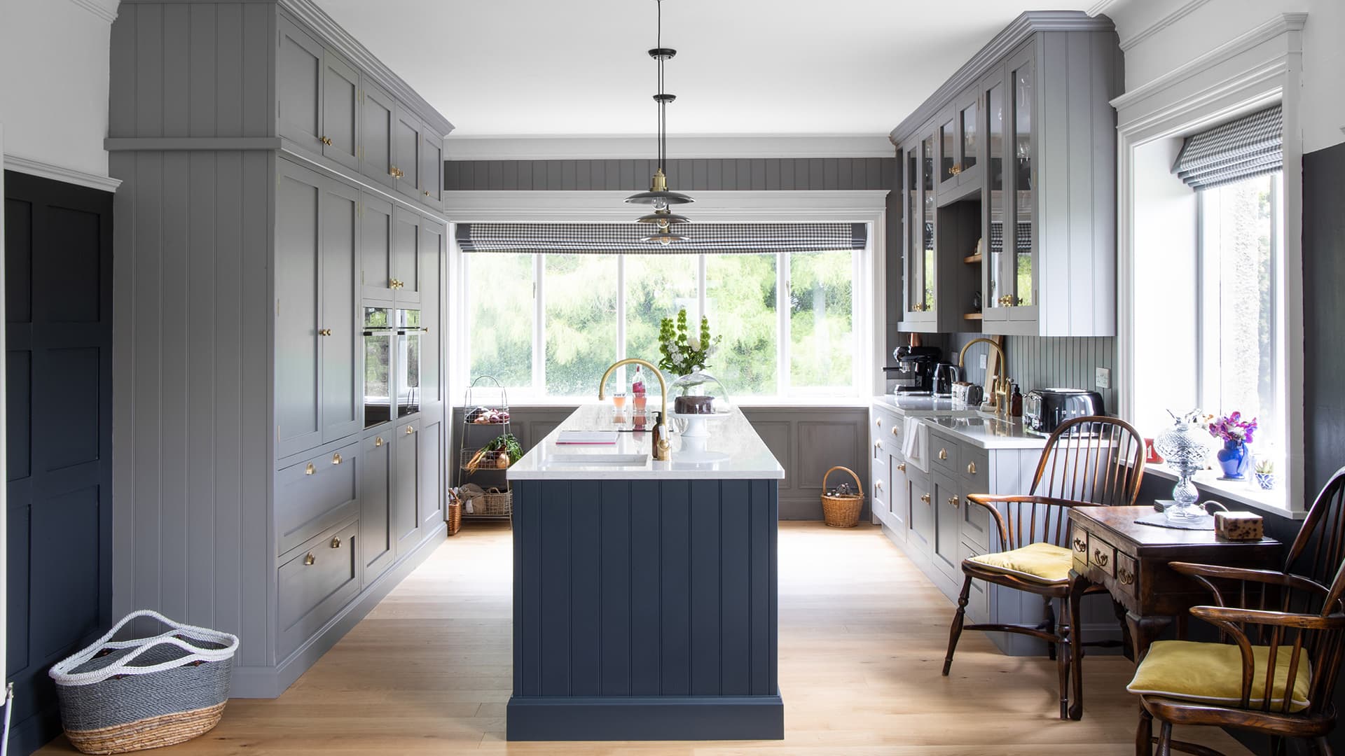 Room view of a kitchen with grey fittings and navy kitchen island