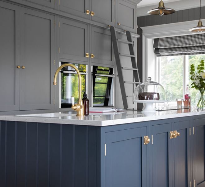 navy kitchen island with grey fitted cupboards in background