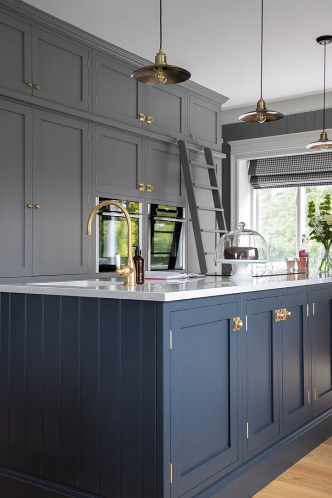 navy kitchen island with grey fitted cupboards in background