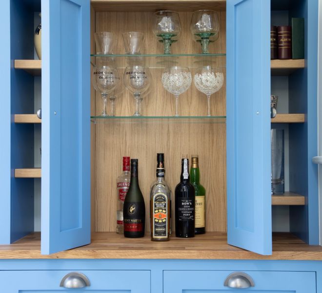 cupboard open with wine and wine glasses inside