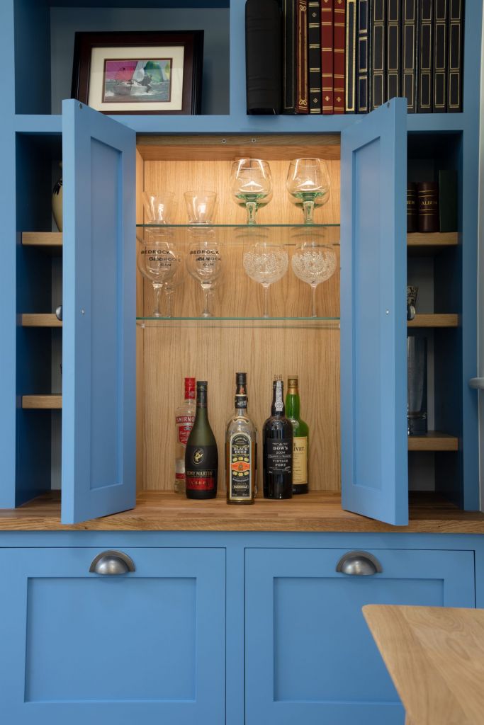 cupboard opened with wine and wine glasses inside