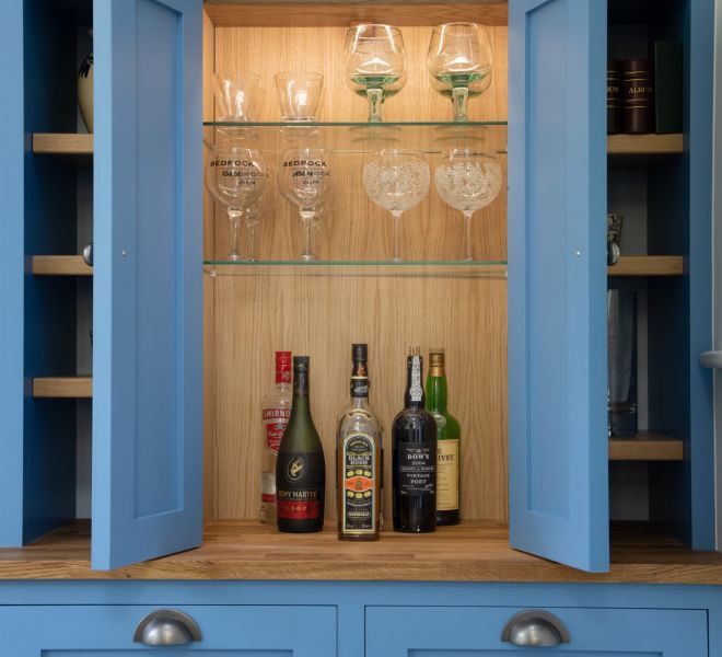 cupboard opened with wine and wine glasses inside