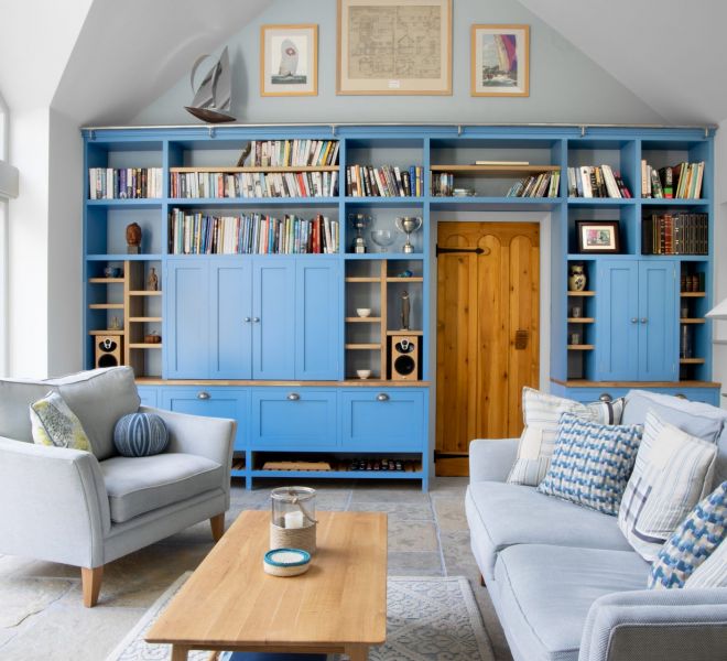 blue fitted cupboards with books stacked on