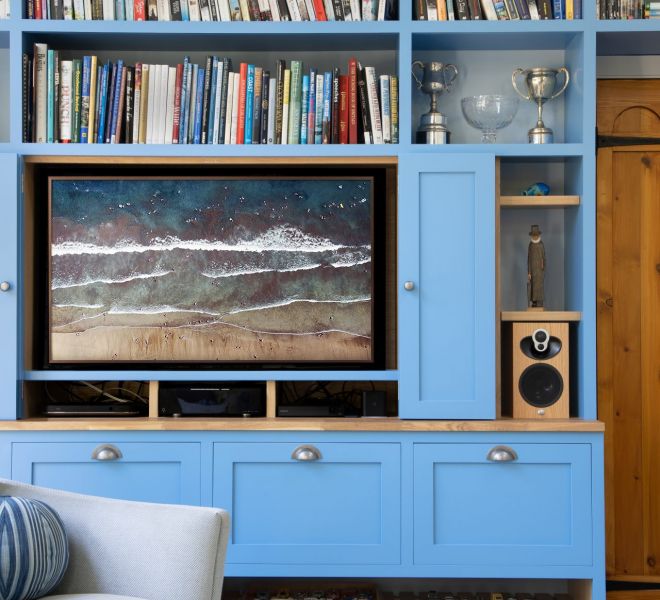 blue fitted cabinets with open doors and tv inside