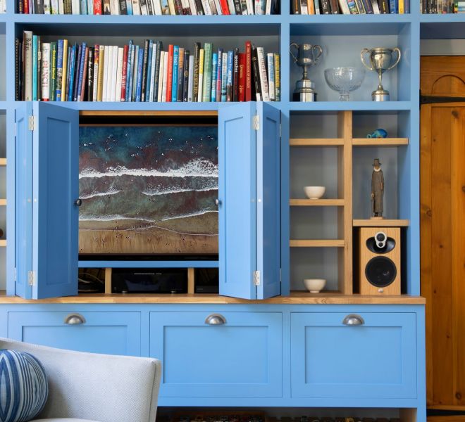 blue fitted cabinets with open doors and tv inside