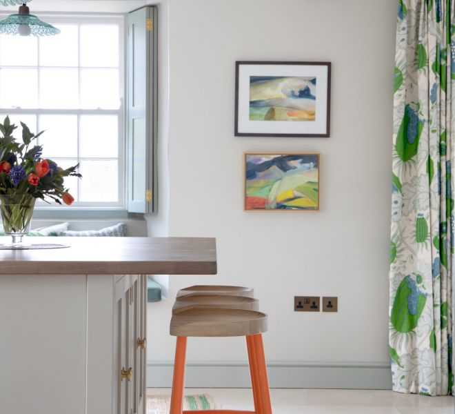 breakfast bar with orange stools and pictures on the wall