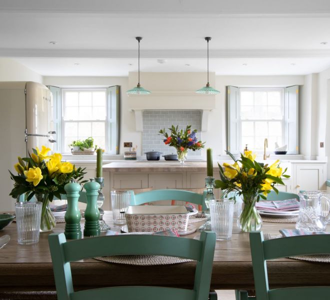 withe kitchen with a table and yellow flowers on top