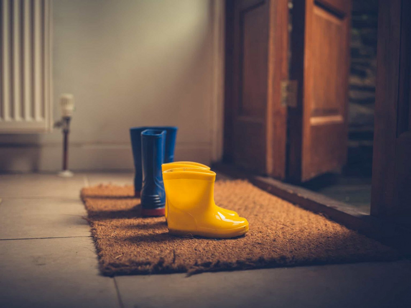 wellington boots on a mat outside door
